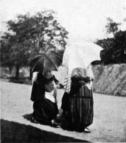 CHRISTIAN WOMEN HIDING FROM THE PHOTOGRAPHER.